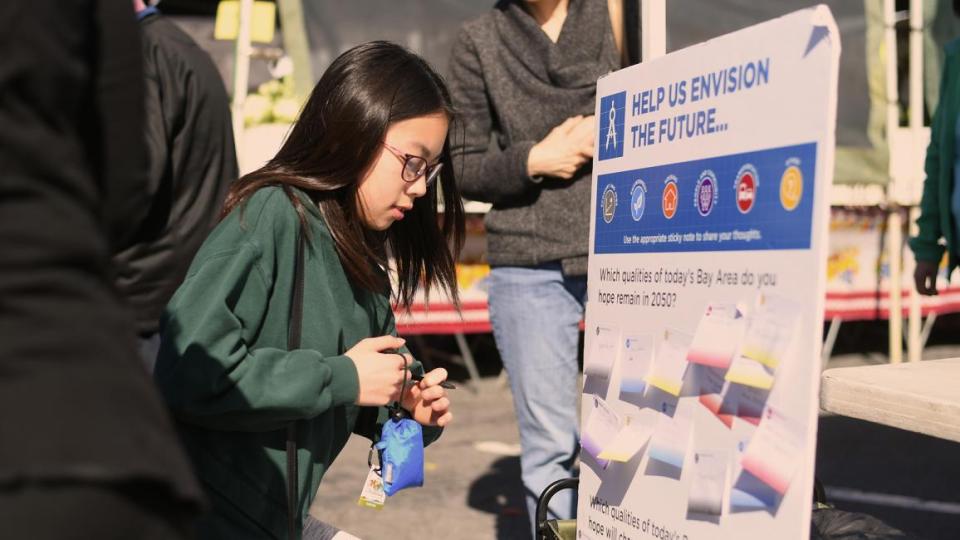 A young woman considers responsed on a display board at a Horizon pop-event.