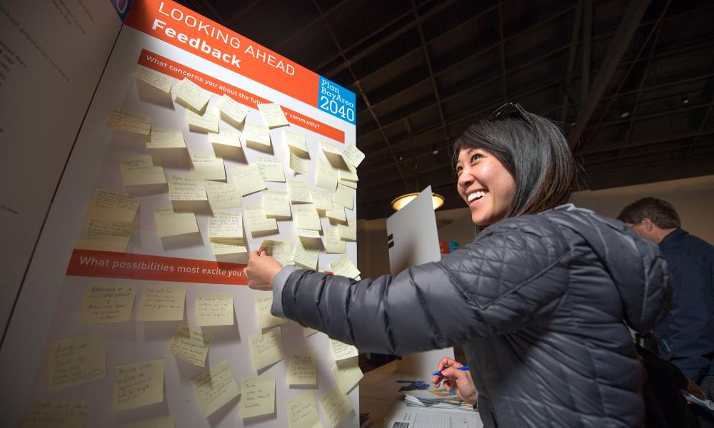 Woman putting post it notes on a board